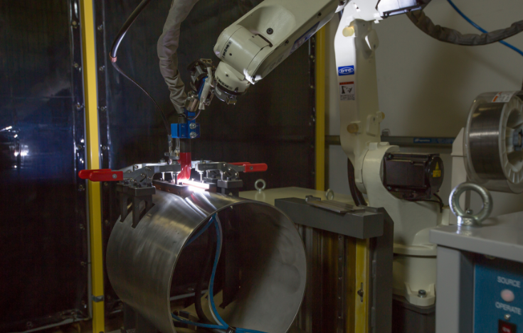 OTC DAIHEN welding robot welds galvanized steel part for an electric vehicle.